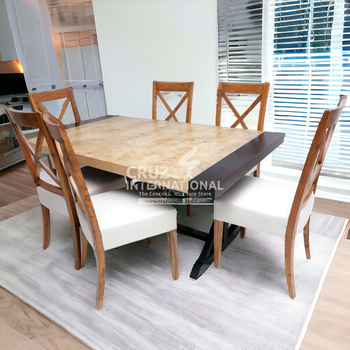 A wooden dining table with brown wood grain and a dark brown tabletop, accompanied by four matching chairs with white cushioned seats and dark wooden legs, set in a bright room with a light carpet.